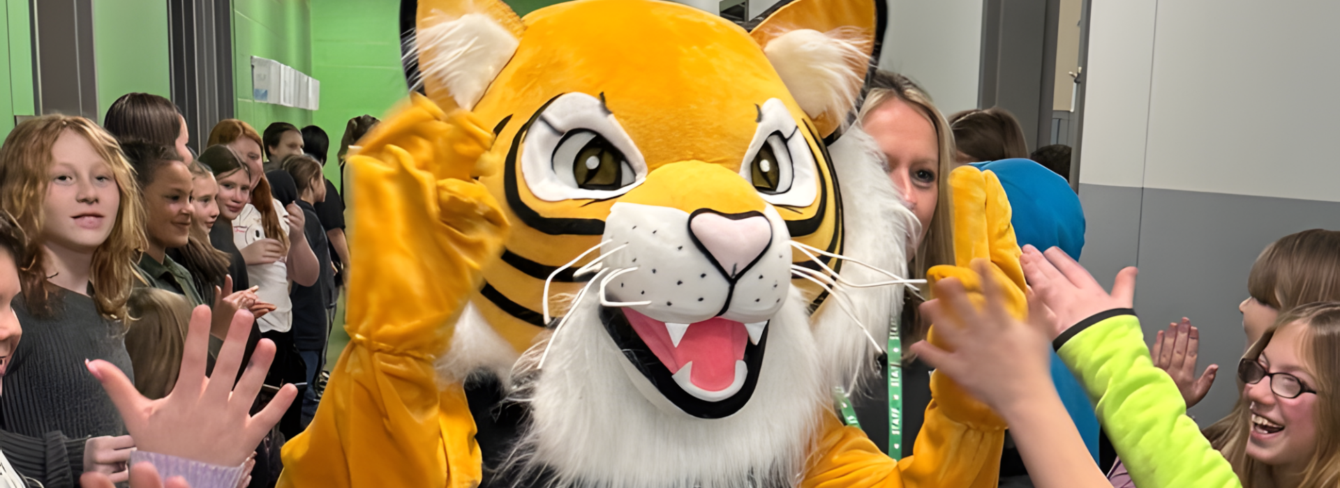 mascot giving high fives to students